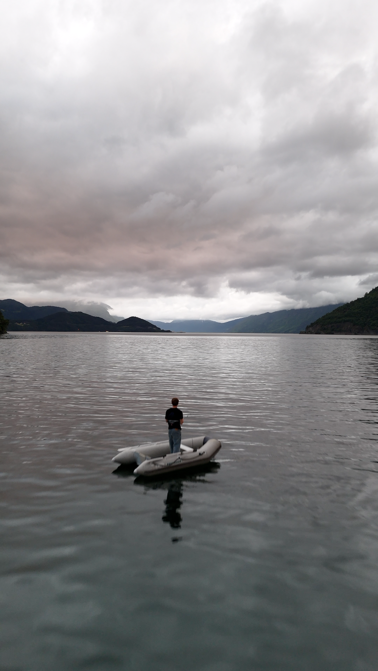 Standing on a small boat in the middle of the fjord